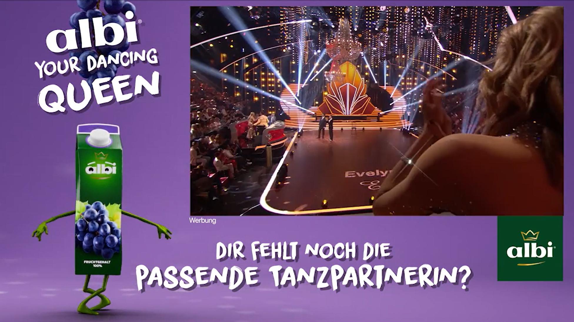 Das Bild zeigt eine Werbeanzeige für Albi-Saft im Stil einer Tanzshow. Links ist eine Packung Traubensaft mit Armen und Beinen abgebildet, daneben ein Bild einer Tanzshow mit einer glitzernden Bühne und Scheinwerfern. Der Text auf dem Bild fragt, ob die passende Tanzpartnerin fehlt.
#!#
Albi,Tanzshow,Werbung,Traubensaft,Bühne,Scheinwerfer,Tanzpartnerin,Glitzer,Werbeanzeige,Fruchtgetränk