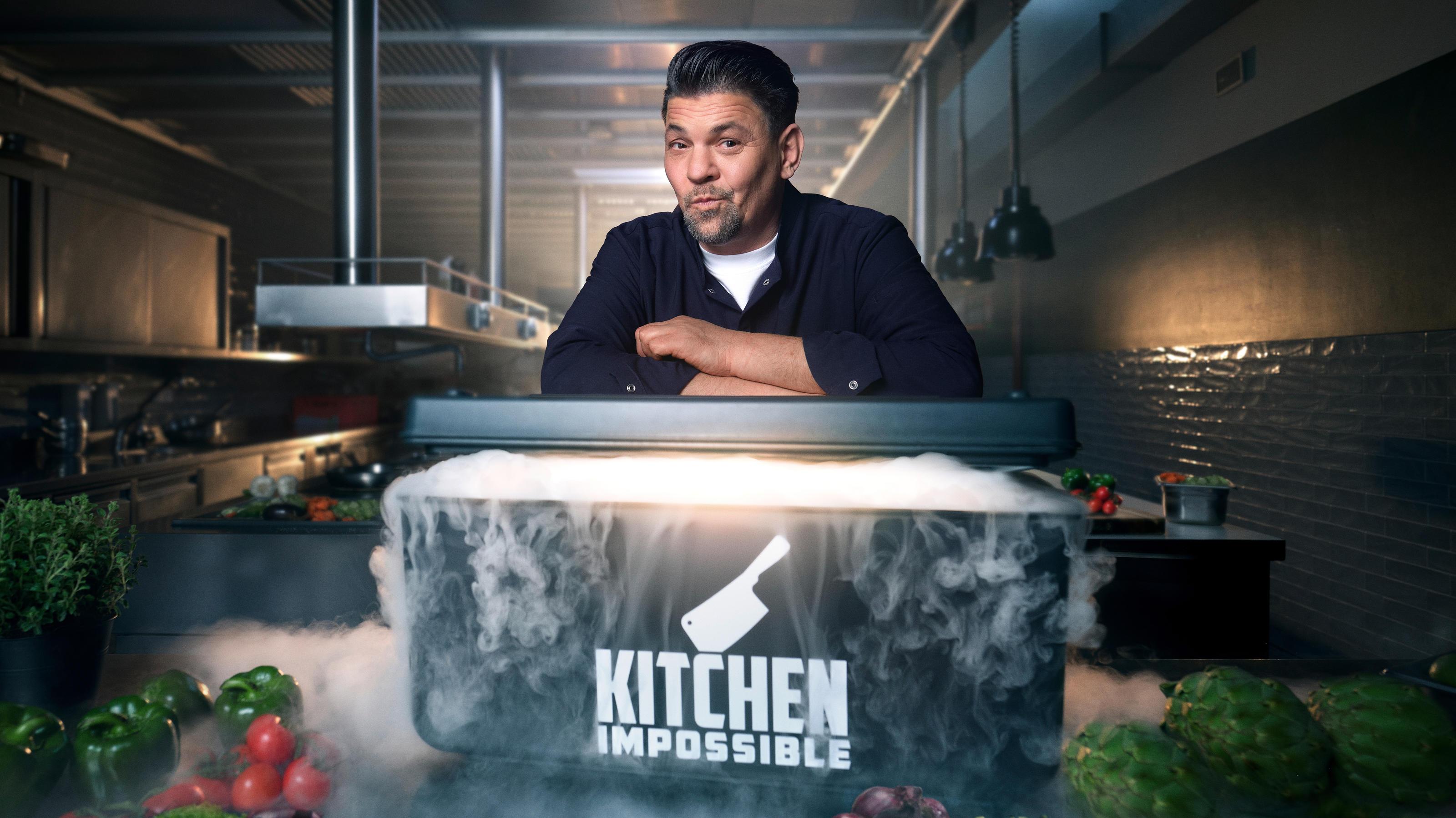Das Bild zeigt einen Mann, der in einer modernen, industriellen Küche steht. Vor ihm befindet sich ein großer Behälter mit der Aufschrift 'Kitchen Impossible', aus dem Nebel aufsteigt. Auf dem Tisch liegen verschiedene frische Zutaten wie Paprika, Tomaten und Kräuter, die auf eine kulinarische Herausforderung hindeuten. Die Beleuchtung ist dramatisch, was die geheimnisvolle und anspruchsvolle Atmosphäre der Szene unterstreicht.
#!#
Küche,Kochen,Herausforderung,Zutaten,Kochkunst,Dampf,Mann,Industriell,Atmosphäre,Fernsehen