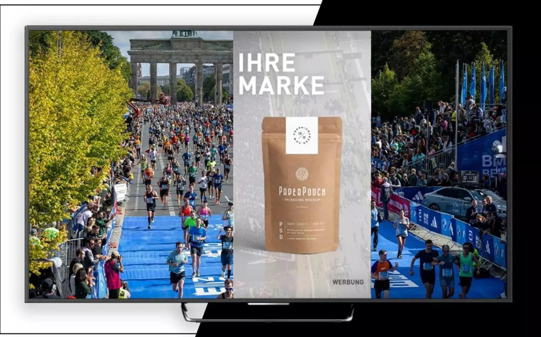 Das Bild zeigt eine große Laufveranstaltung, die vor dem Brandenburger Tor in Berlin stattfindet. Viele Teilnehmer laufen auf einer blauen Strecke, die von Zuschauern gesäumt ist. Auf der rechten Seite des Bildes befindet sich eine Werbeanzeige für ein Produkt namens 'PodePouch'. Über dem Produkt steht der Schriftzug 'IHRE MARKE'. Die Veranstaltung scheint gut besucht zu sein und das Wetter klar und sonnig.
#!#
Marathon,Brandenburger Tor,Berlin,Läufer,Zuschauer,Werbung,PodePouch,Sportveranstaltung,blauer Laufweg,Publikum