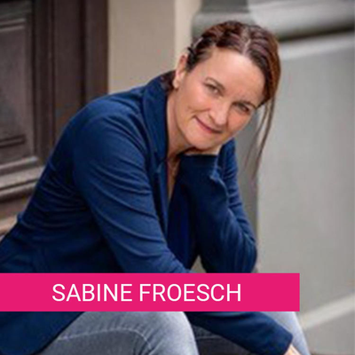 Das Bild zeigt eine Frau in einem blauen Oberteil und Jeans, die entspannt auf einer Treppe sitzt. Sie lehnt sich mit einem Ellbogen auf einem Knie ab und schaut freundlich in die Kamera. Im Hintergrund ist eine hölzerne Tür und eine Wand zu sehen.
#!#
Frau,blau,entspannt,Treppe,Porträt,Lächeln,Kamera,Freundlichkeit,Tür,Wand
